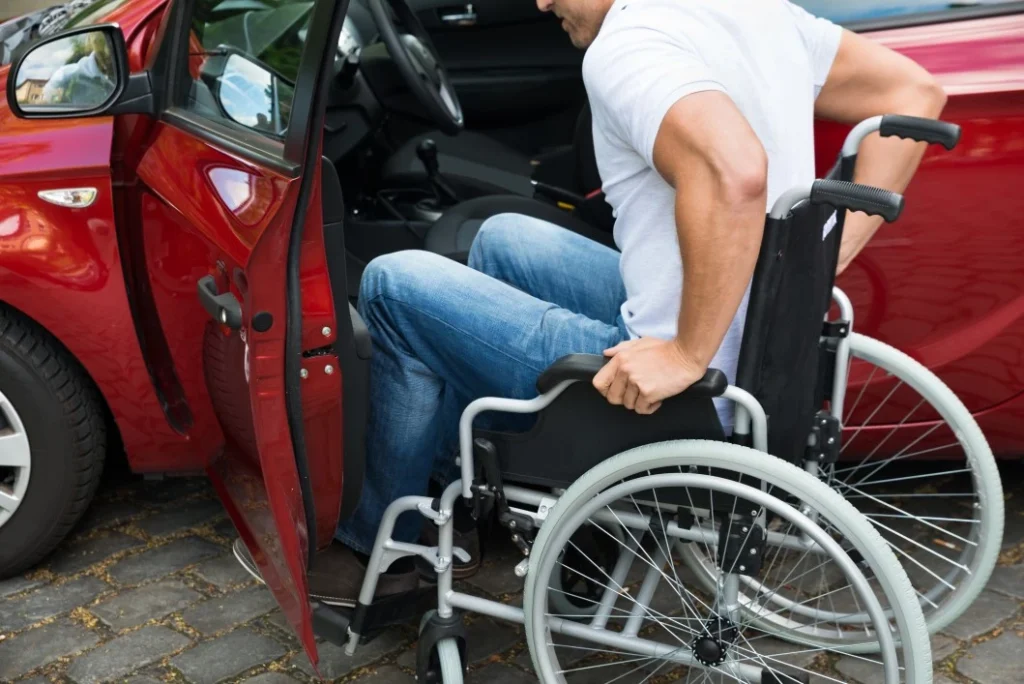 Man in wheelchair getting into the car