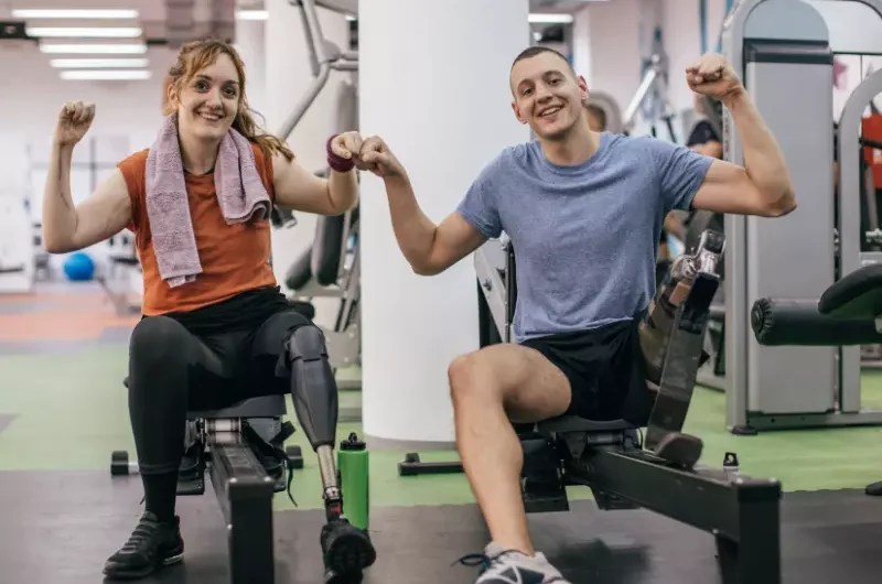 Two disabled friends in the gym pumping fists